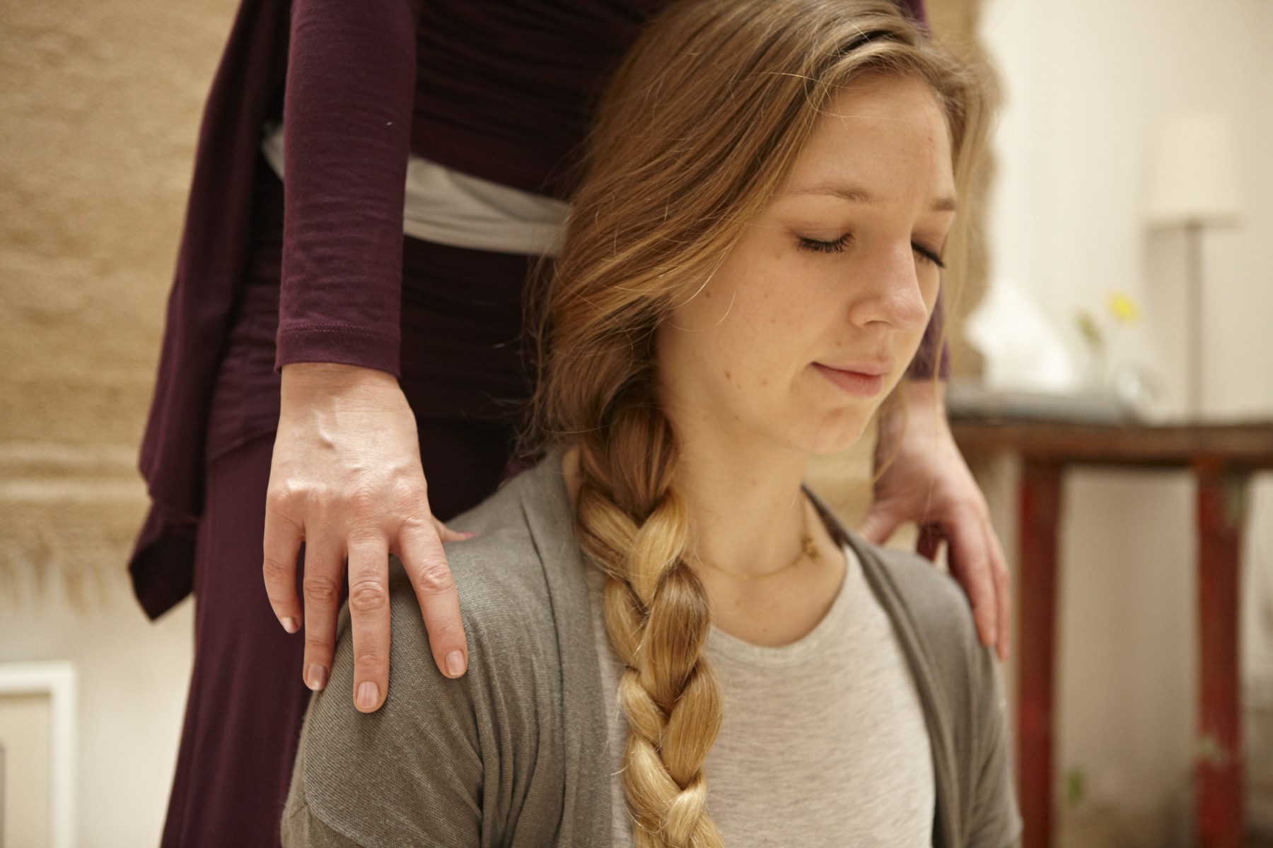 Amy's hands resting on the shoulders of a seated client